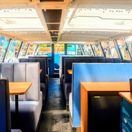 Spacious boat interior with booth seating and glass roof.