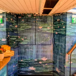 Interior wall with lily pad mural and staircases leading up both sides.